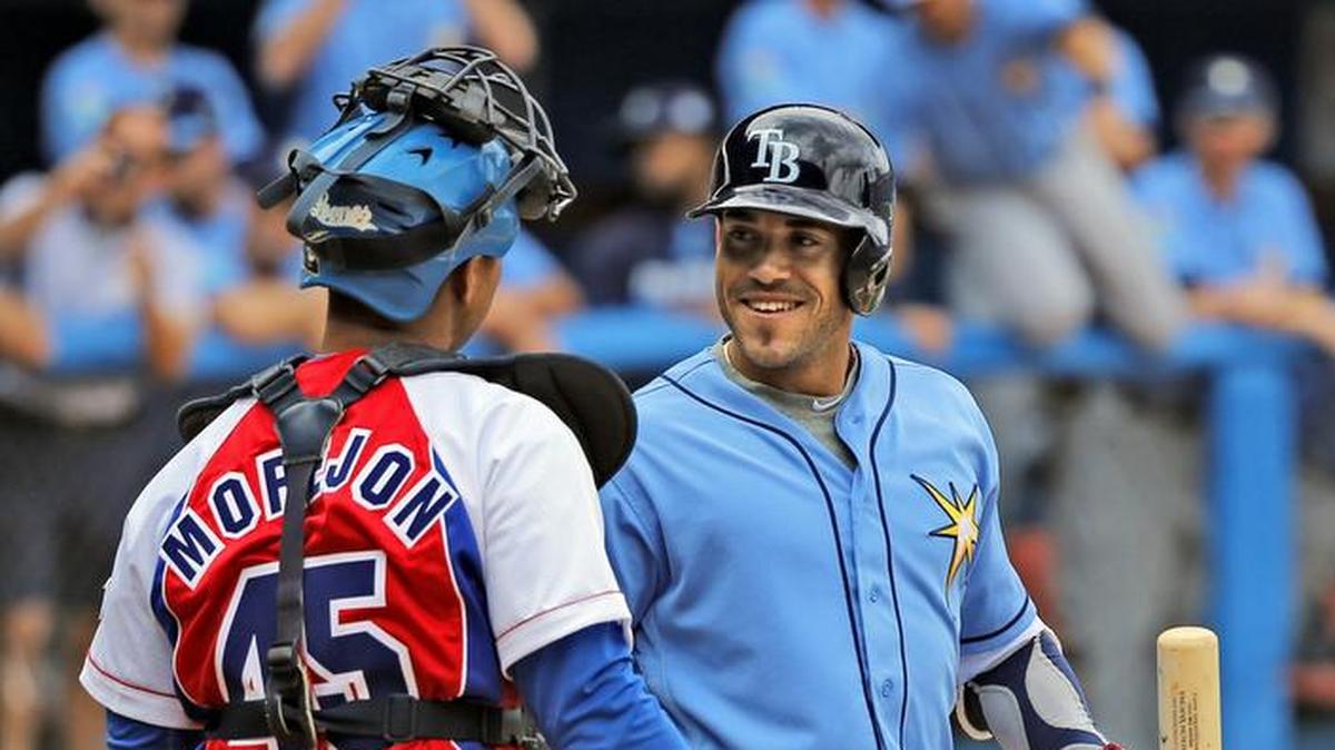 Dayron Varona, un pelotero de los Rays nacido en Cuba, saluda al catcher del equipo cuabano Frank Morejón, durante un juego en el Estadio Latinoamericano en La Habana, el 22 de marzo de 2016.