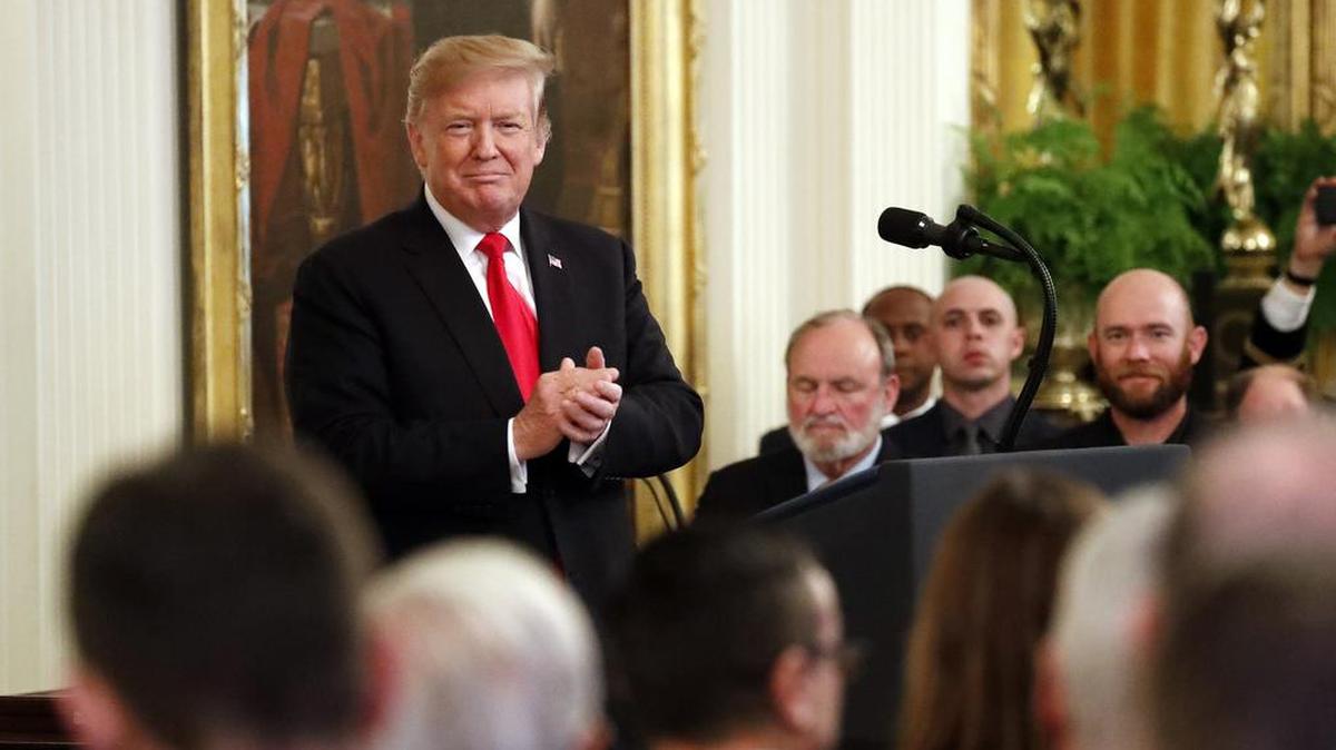 El presidente Donald Trump aplaude durante la entrega de la Medalla de Honor a la familia del sargento del ejército Travis Atkins, quien falleció en Irak.