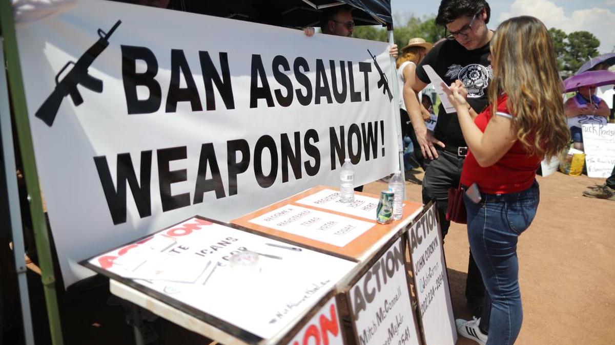 Una protesta contra el presidente Donald Trump que también sirvió para registrar nuevos votantes muestra una pancarta que dice “Prohíban Todas las Armas de Asalto”, el miércoles 7 de agosto de 2019, en El Paso, Texas.