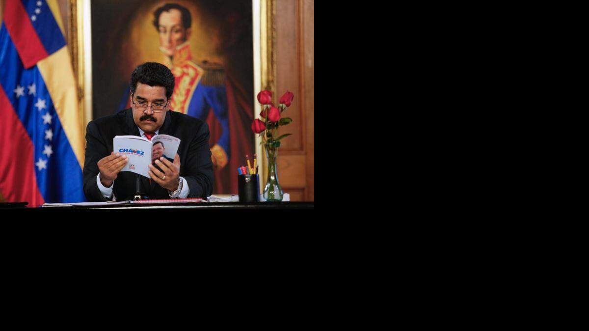 
El presidente venezolano Nicolás Maduro lee un libro durante un programa de TV transmitido desde el palacio presidencial de Miraflores, en Caracas, el 2 de septiembre.
