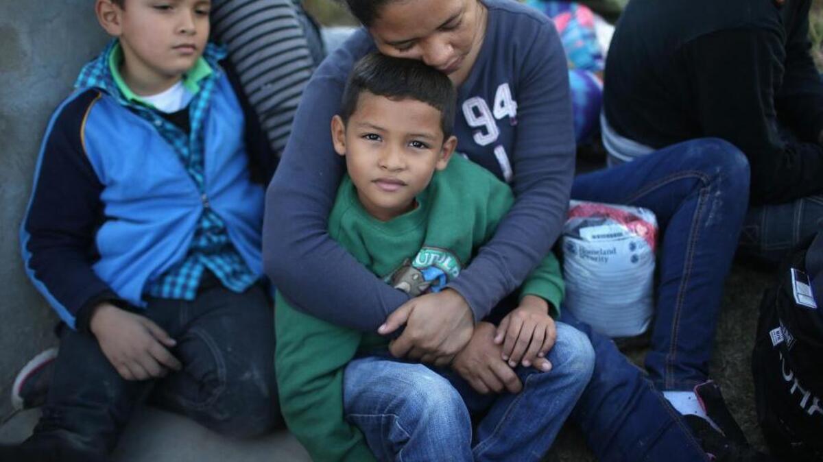 Una madre hondureña y sus hijos esperan ser atendidos por agentes de la Patrulla Fronteriza, en Texas.