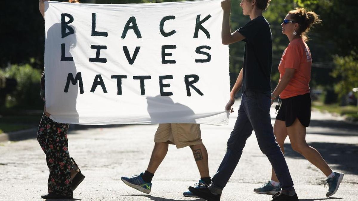 Un grupo de manifestantes lleva una pancarta con el letrero Black Lives Matter en una marcha organizada por jóvenes en Kalamazoo, Michigan, el 14 de junio.