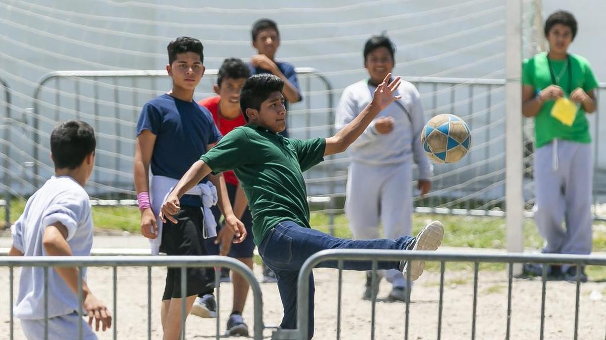 Niños migrantes juegan al fútbol en el Refugio Temporal de Homestead para Niños No Acompañados, en Homestead, Florida, el 19 de abril de 2019. El refugio ya no está abierto