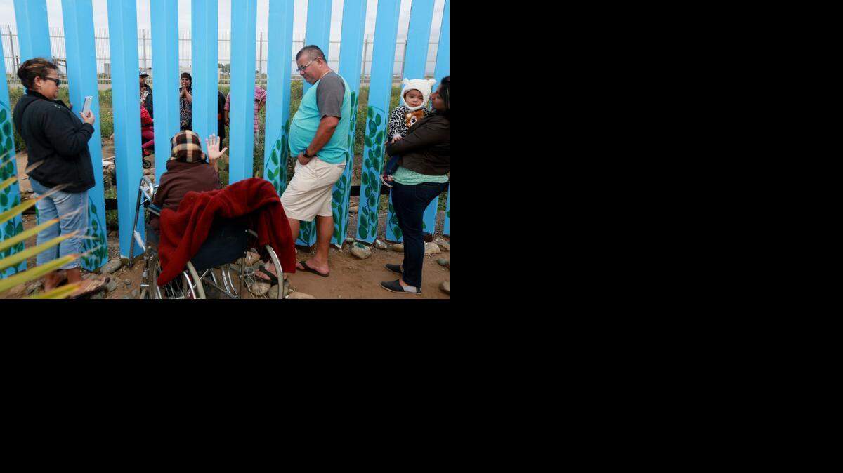 
Familiares a ambos lados de la frontera entre México y Estados Unidos se visitan junto a la valla que separa a ambos países en Tijuana, el 22 de febrero.
