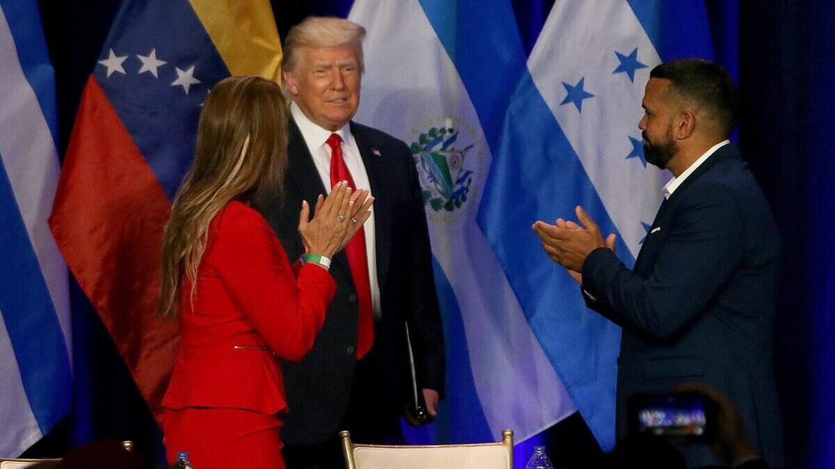 Karla Salvatierra (left) and Hiram Turrull, welcomed U.S President Donald J. Trump as he enters the stage as he meets with a group of South Florida community members during the Latinos for Trump Roundtable at the Trump National Doral in Doral Florida, on Friday, September 25th, 2020.