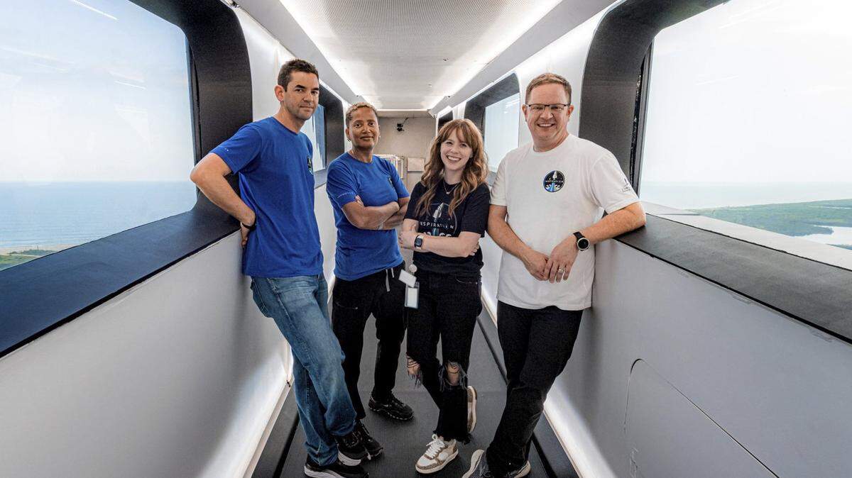 In this July 28, 2021 photo provided by John Kraus, from left, Jared Isaacman, Sian Proctor, Hayley Arceneaux and Chris Sembroski stand in the crew access arm at Launch Complex 39A at Kennedy Space Center in Florida. They will use this arm to board the Falcon 9 rocket on launch day. (John Kraus/Inspiration4 via AP)
