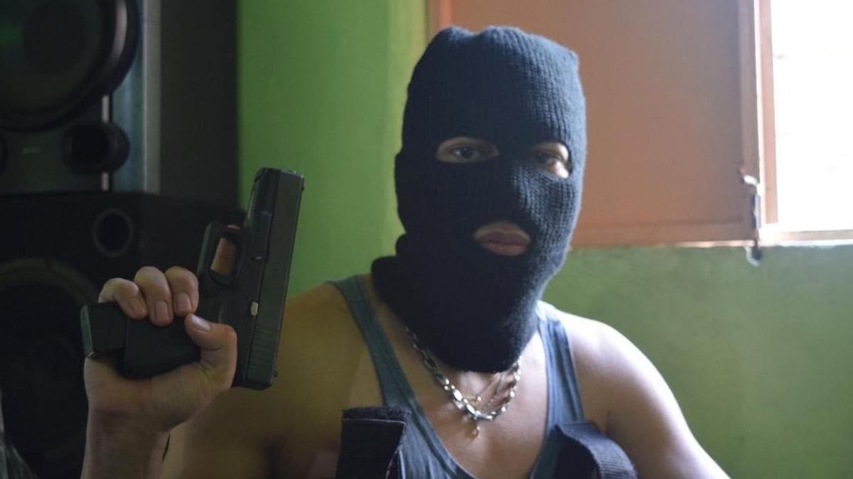 En Caracas, un pandillero muestra una pistola presuntamente tomada a un policía asesinado, a fines del año pasado.