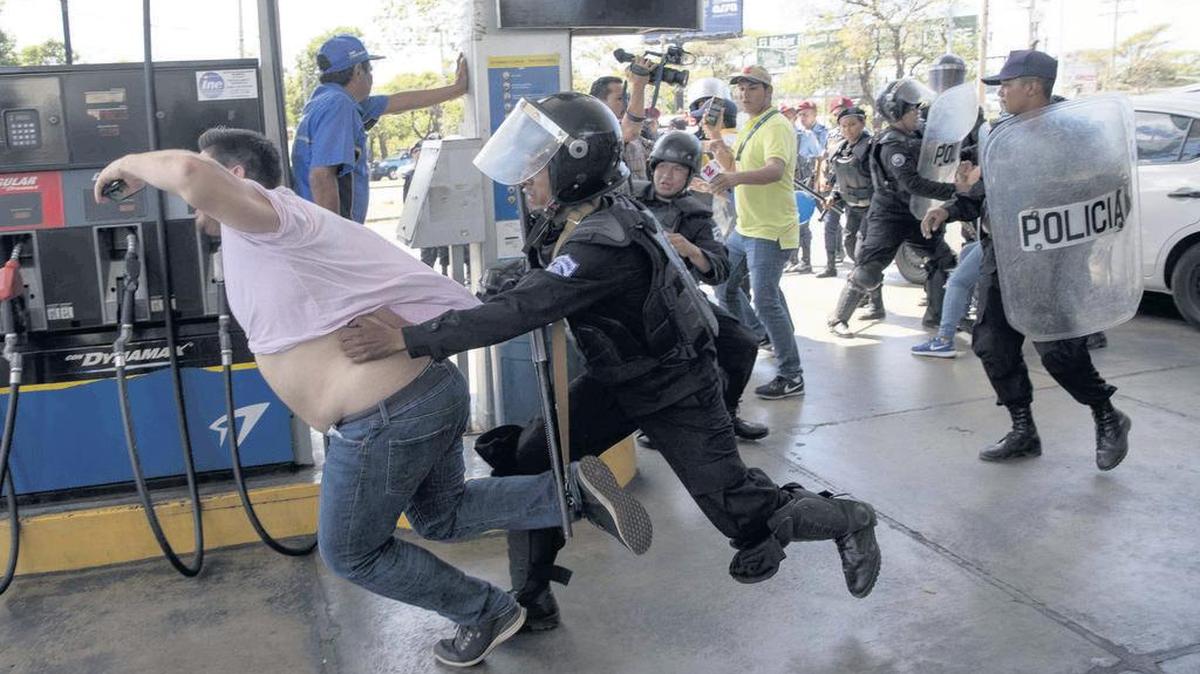 Foto de archivo del 16 de marzo de 2019 en la que miembros de la Policía Nacional intentan detener al reportero gráfico Luis Sequeira, de la agencia AFP, durante una manifestación contra el Gobierno de Daniel Ortega este sábado, en Managua, Nicaragua. La Policía de Nicaragua replegó con violencia ese sábado a un grupo de periodistas que daban cobertura a una manifestación antigubernamental, en el marco de la grave crisis sociopolítica que afecta al país.
