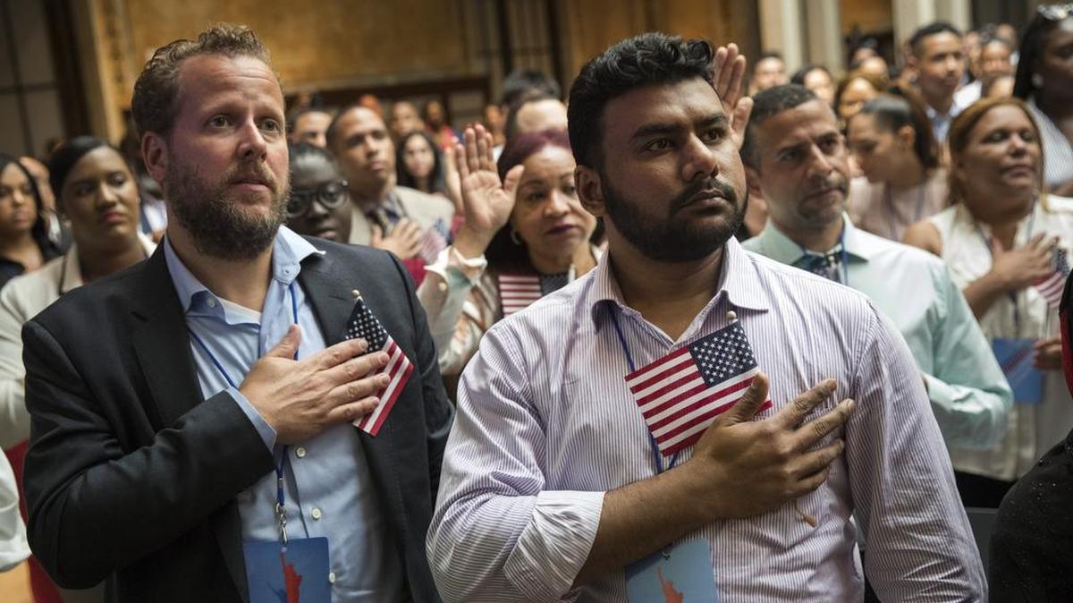 Nuevos ciudadanos estadounidenses recitan el Juramento de Lealtad a la Bandera en una ceremonia de naturalización en la Biblioteca Pública de Nueva York, el 3 de julio.