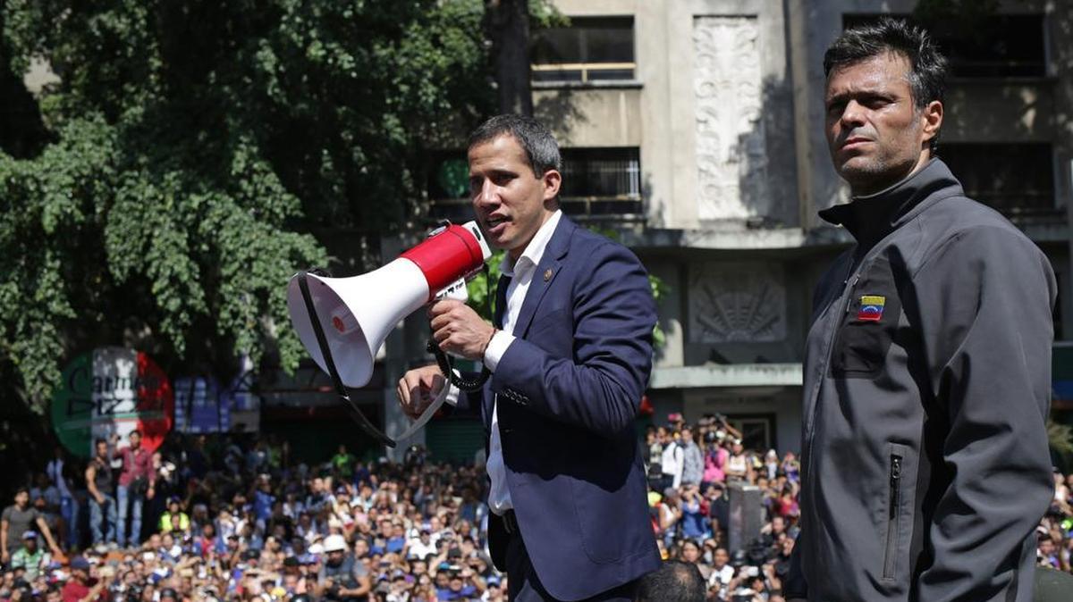 El presidente interino de Venezuela, Juan Guaidó (izq.) y el ex preso político Leopoldo López hablan con partidiarios el martes en Caracas.