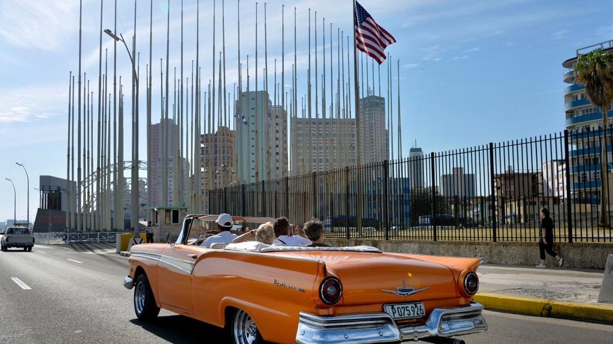 Un automóvil antiguo pasa cerca de la embajada de EEUU en La Habana.