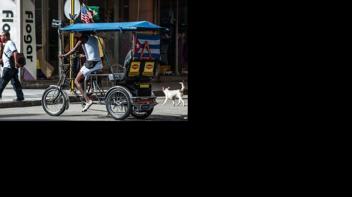 
Un bicitaxi exhibe una bandera de Cuba y otra de Estados Unidos en una calle de La Habana, el miércoles pasado.
