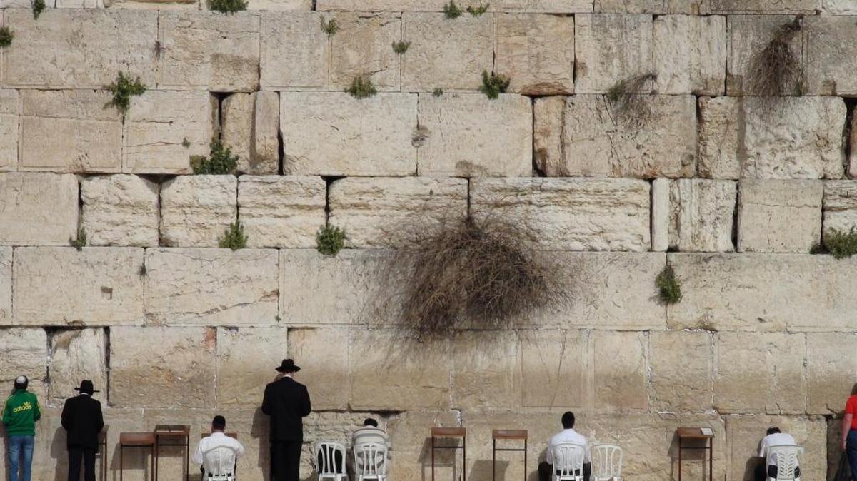 Un grupo de personas reza en el Muro de las Lamentaciones en Jerusalén, lugar santo para la religión judaica.