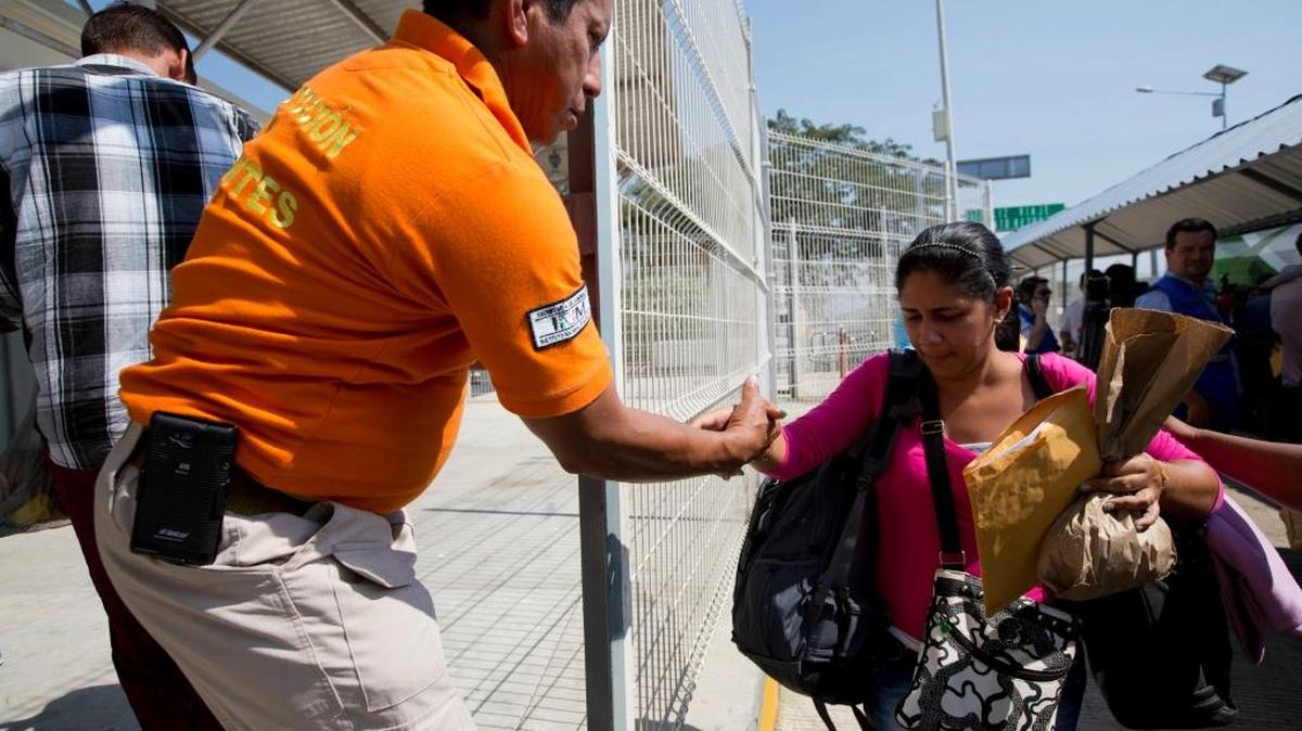 Un agente de inmigración de México ayuda a una cubana a su llegada a Ciudad Hidalgo, en la frontera con Guatemala, el miércoles pasado.