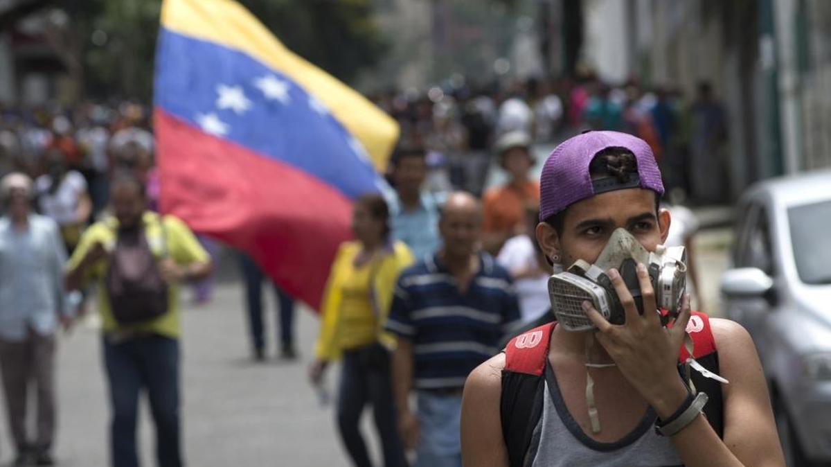 Un joven usa una mascarilla para protegerse de los gases lacrimógenos lanzados por la policía, durante una manifestación en Caracas el 18 de mayo.