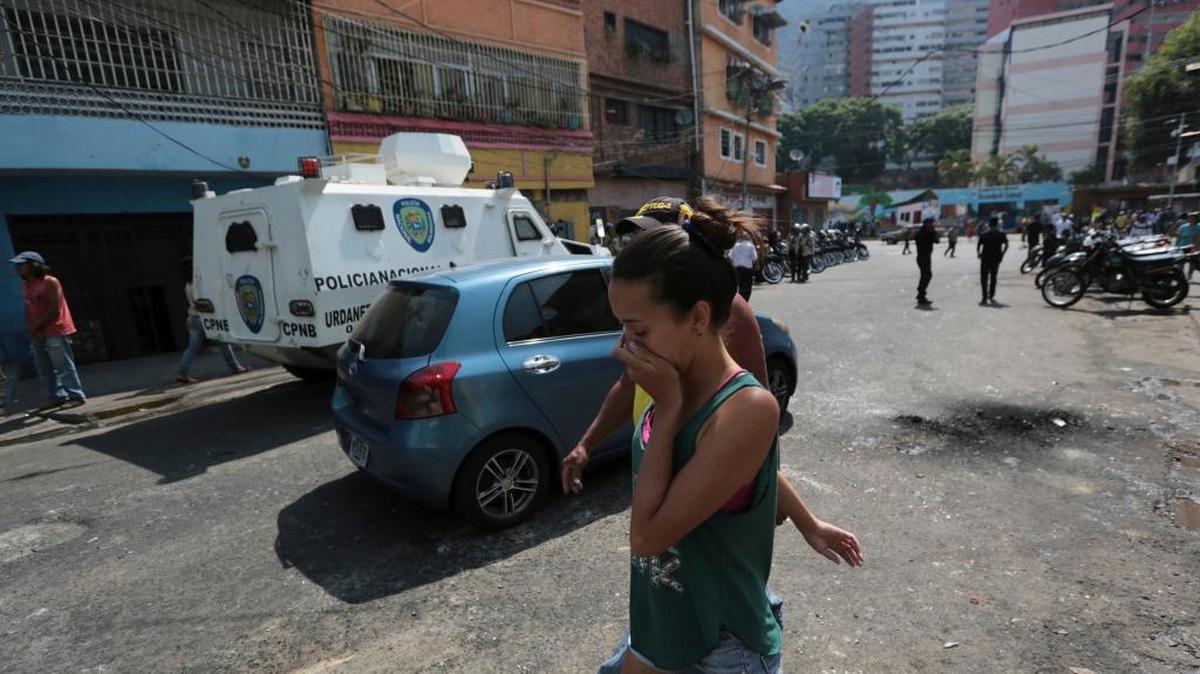 Una residente de Caracas se cubre la cara después que la Guardia Nacional Bolivariana lanzara gases lacrimógenos durante una protesta antigubernamental el 12 de abril. En la cobertura de las manifestaciones, la prensa también ha sido víctima de la represión.