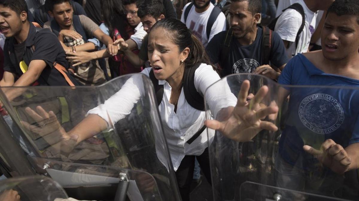 Estudiantes venezolanos chocan con la policía el viernes, en una protesta en Caracas contra el golpe a la Asamblea Nacional.