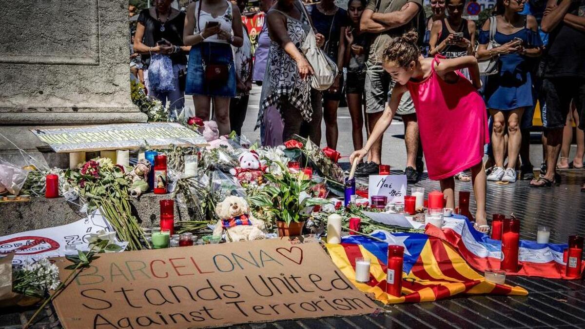 La gente coloca flores, velas y mensajes en un tributo en Barcelona a las víctimas del ataque terrorista del jueves.