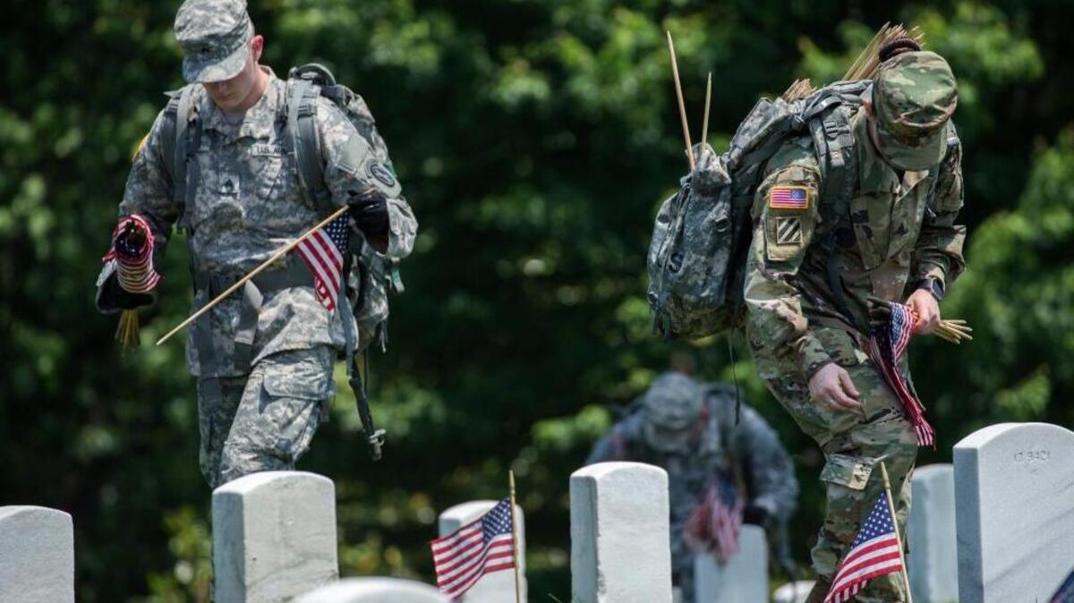 Soldados del tercer regimiento de la Infantería de Estados Unidos colocan banderas sobre tumbas en el Cementerio Nacional de Arlington, Virginia, el jueves pasado.