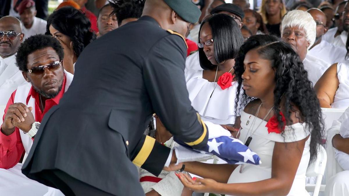 Myeshia Johnson, la esposa del sargento La David Johnson, caído en combate en Níger, recibe una bandera en el funeral en Hollywood, Florida.