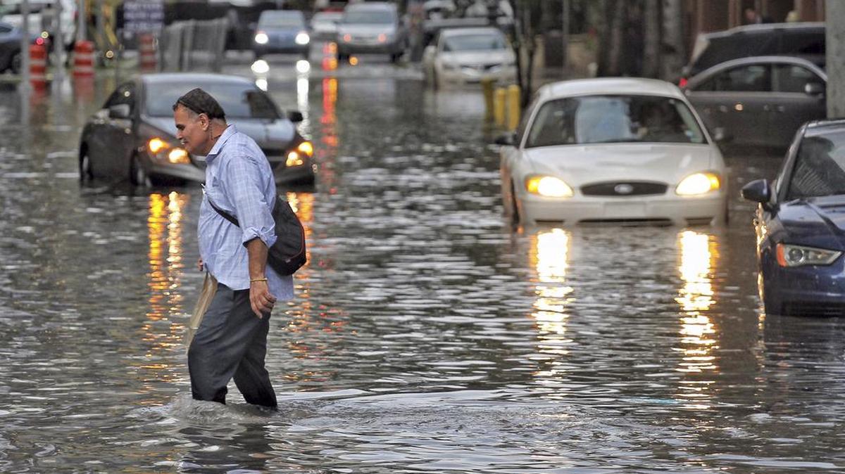 Un peatón cruza una calle inundada en el distrito de Brickell, en Miami, el martes 1 de agosto.