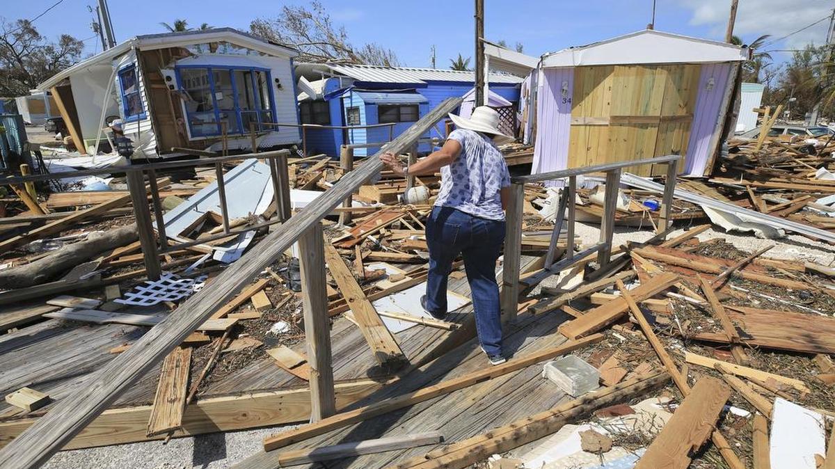 Una mujer camina entre los destrozos causados por el huracán Irma en el parque de casas móviles Seabreeze, en Islamorada.