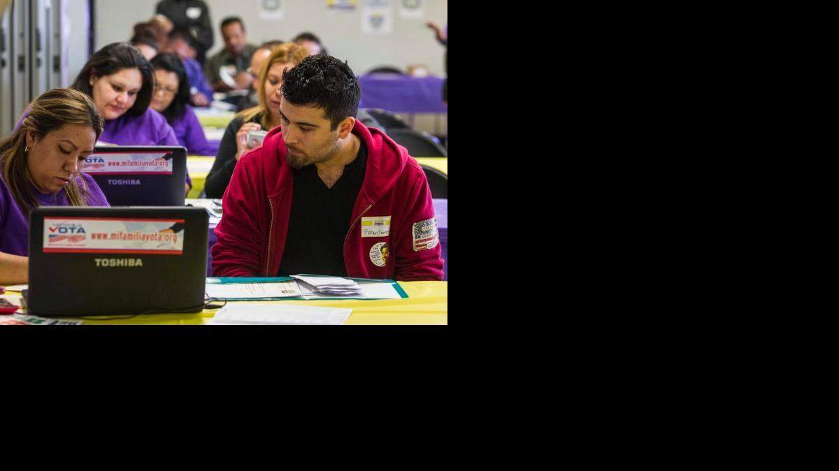 
La asesora de salud Kathy Santana (izq.) ayuda a Rubén Torres a inscribirse en un seguro médico, en el marco de la ley conocida como Obamacare, en Commerce, California, el año pasado.
