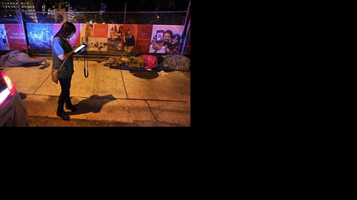 
Janay Guerrero, de la Ciudad de Miami, cuenta a los desamparados que duermen en la calle, junto a una obra en construcción en el downtown de Miami, a fines de enero.
