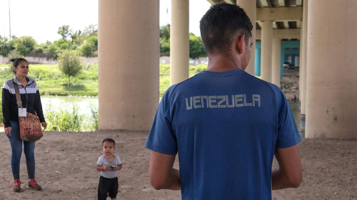 Varios inmigrantes venezolanos esperan por las autoridades fronterizas de Estados Unidos tras cruzar el Rio Grande, en Texas, el domingo 18 de septiembre de 2022. (Carl Juste/Miami Herald)