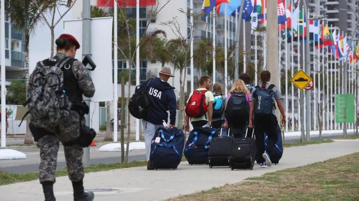 Un oficial de seguridad fuertemente armado custodia a un grupo de atletas a su arribo a la Villa Olímpica en Río de Janeiro el 2 de agosto para participar en los Juegos Olímpicos.
