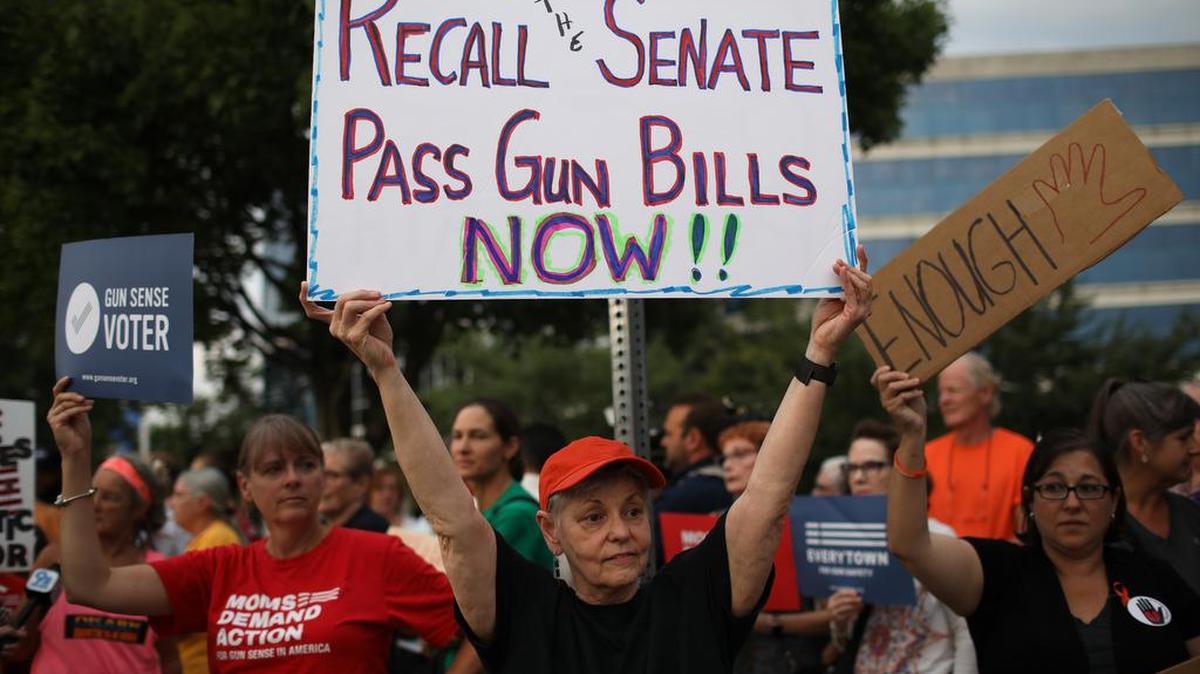 “Llamen al Senado, aprueban leyes de control de armas ahora” dice la pancarta de esta activista durante una protesta frente a la sede de la Asociación Nacional del Rifle (NRA), el 5 de agosto de 2019, en Fairfax, Virginia.