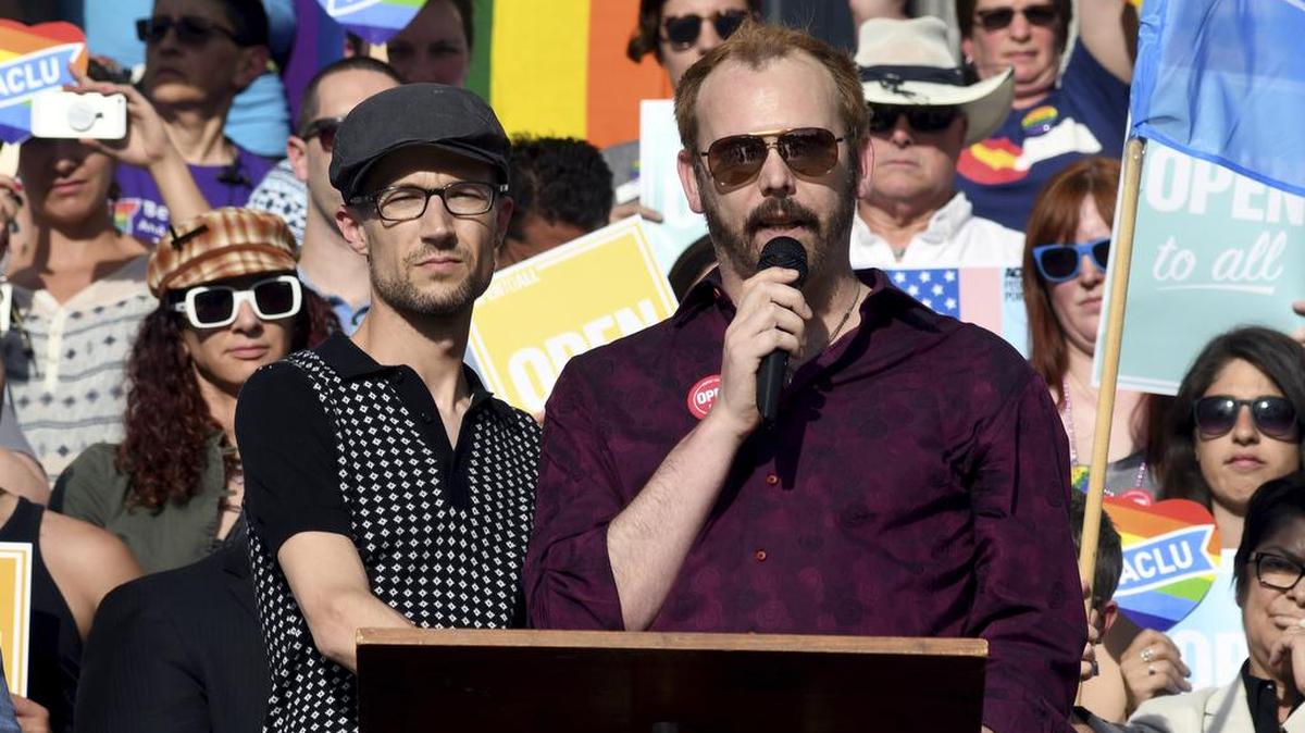 Charlie Craig (der.), junto a su pareja, Dave Mullins, habla en una concentración en Denver después que el Tribunal Supremo falló a favor de un panadero que rehusó hacer el cake para la boda de la pareja, el 4 de junio.
