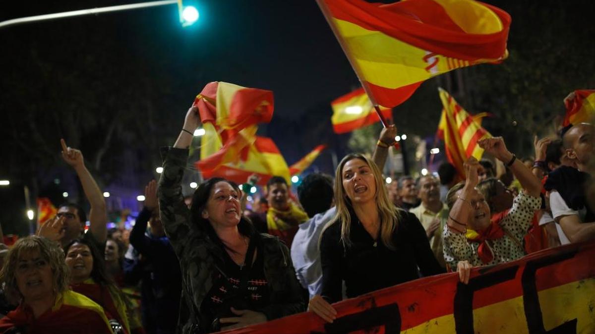 Manifestantes contra la independencia de Cataluña agitan banderas españolas mientras marchan en el centro de Barcelona, el 27 de octubre.