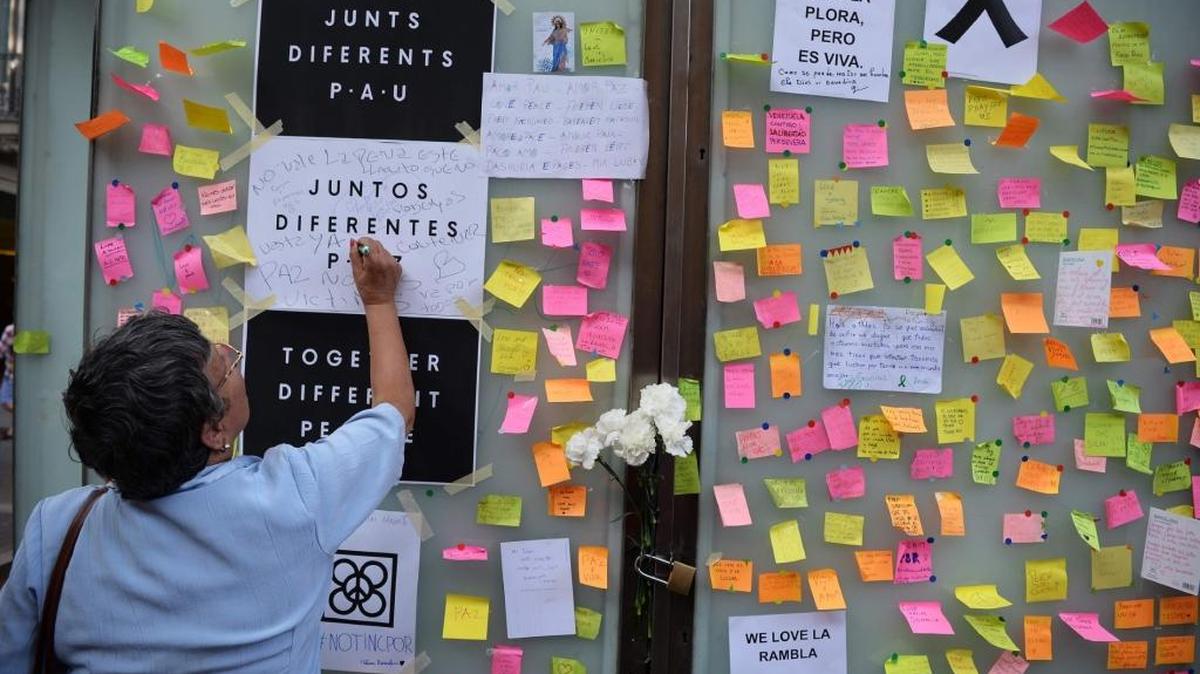 Una mujer escribe un mensaje de condena al ataque terrorista en Barcelona, que mató a 14 personas y dejó más de 100 heridos, en las Ramblas, el 18 de agosto.