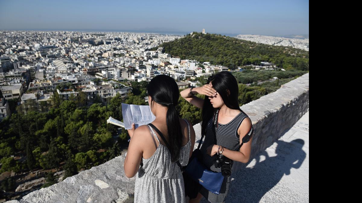 
Dos turistas visitan la Acrópolis de Atenas mientras el gobierno griego discute nuevas medidas de austeridad.
