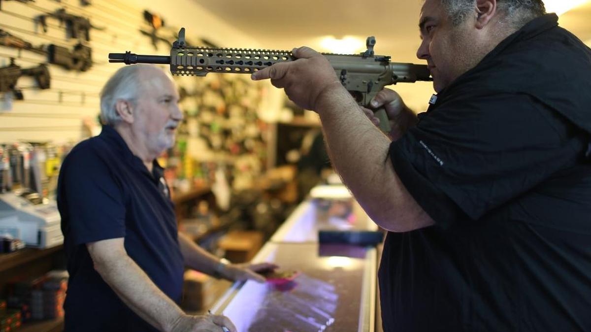 William Gordon (izq.) ayuda a un cliente a escoger un arma en un establecimiento de Delray Beach, en la Florida, el 5 de enero, cuando el presidente Obama anunció una acción ejecutiva para reducir la violencia en la nación.