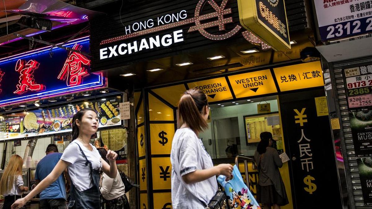 
Varias personas pasan junto a un establecimiento de cambio de divisas en Hong Kong. El gobierno chino devaluó el yuan el martes pasado.
