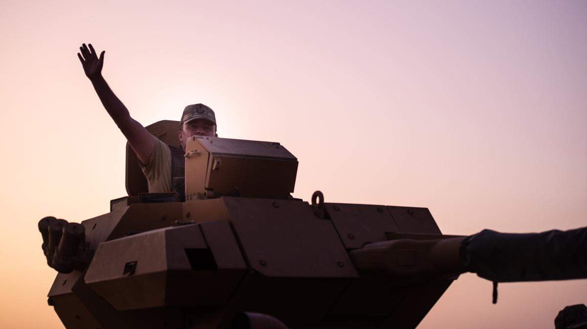 Un soldado turco en un tanque saluda mientras se prepara para cruzar la frontera con Siria, desde Akcakale, Turquía, el miércoles 9 de octubre de 2019. El desplazamiento de tropas es parte de la estrategia de Turquía de retomar el norte de Siria, que en la actualidad está bajo el control de kurdos sirios.