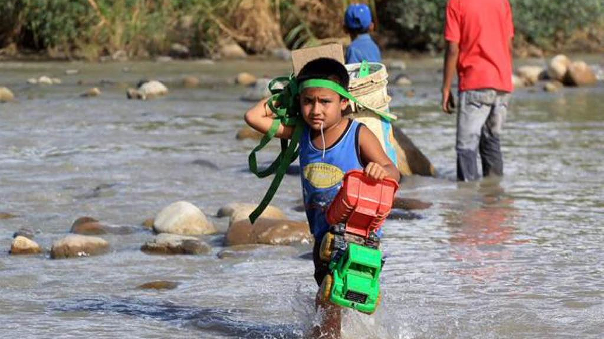
Un niño cruza el río Táchira desde Venezuela hacia Colombia, en medio del éxodo causado por el cierre de la frontera.

