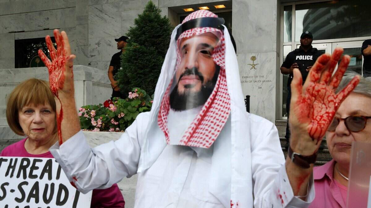 Un hombre con una máscara del príncipe saudita Mohammed bin Salman y otras personas protestan la desaparición del periodista Jamal Khashoggi, el 10 de octubre de 2018, frente a la Embajada de Arabia Saudita en Washington D.C.