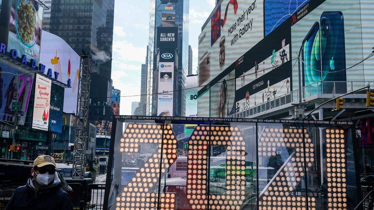 FILE - In this Dec. 21, 2020, file photo, a man walks past giant numerals for “2021” to be used in the upcoming the New Year’s eve festivities in New York’s Times Square. (AP Photo/Frank Franklin II, File)