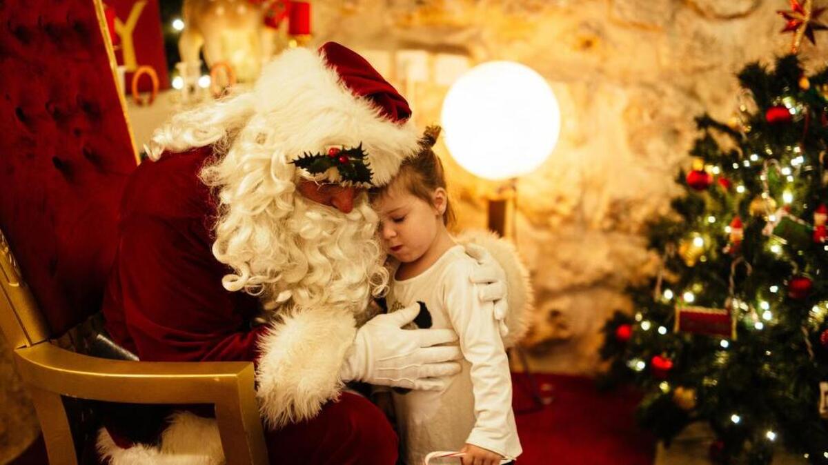 San Nicolás abraza a una niña en un evento especial en la Ciudad Vieja de Jerusalén, en Israel, el 19 de diciembre.