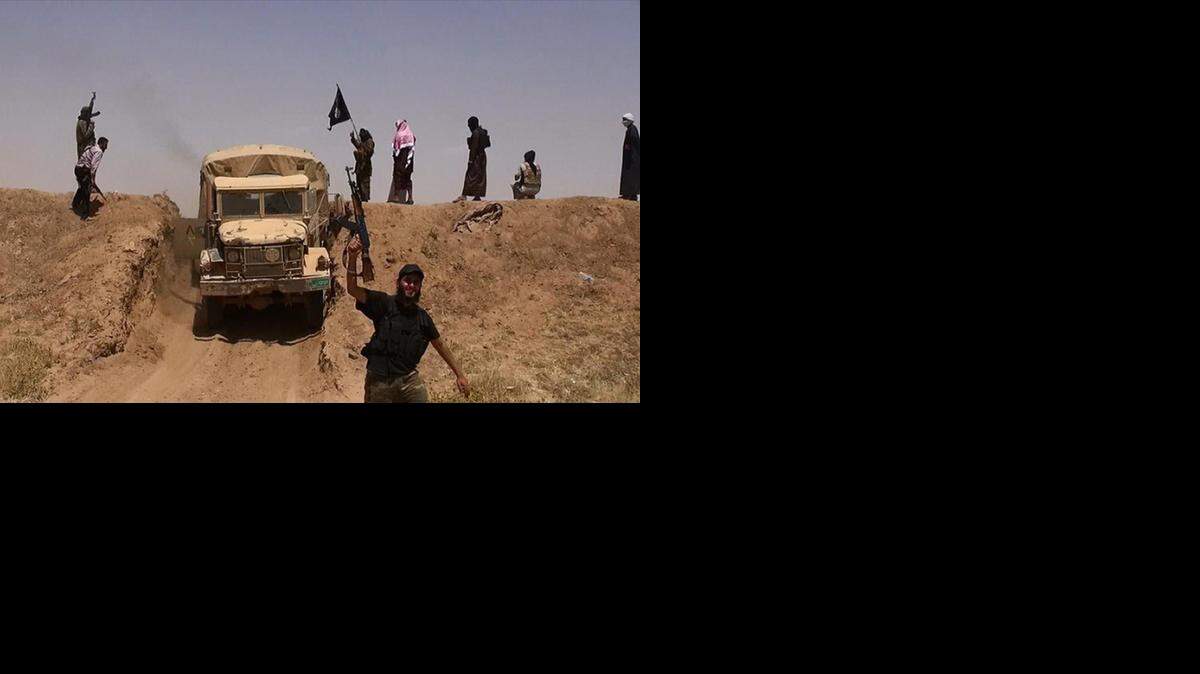 
Militantes del grupo yihadista Estado Islámico (EI) exhiben sus armas y su bandera en un camino recién abierto en el norte de Irak, cerca de la frontera con Siria, el pasado junio.
