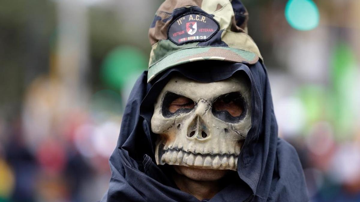 Un manifestante enmascarado marcha en protesta el 1ro de mayo en Bogotá, Colombia.