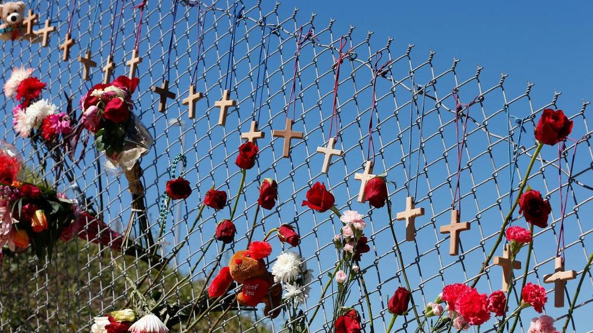 Flores y cruces en homenaje a las víctimas de la matanza en la secundaria Marjory Stoneman Douglas adornan una cerca de la escuela, en Parkland, condado Broward, el 16 de febrero de 2018.