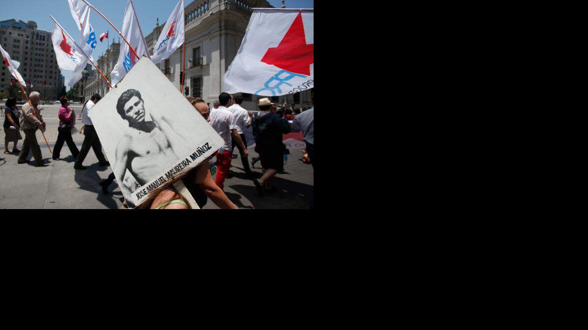 
Manifestantes con afiches de víctimas de la dictadura de Augusto Pinochet, durante una marcha en Santiago de Chile que fue realizada el 10 de diciembre.


