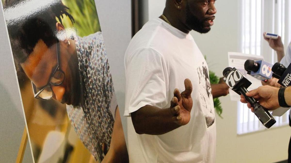 Michael McGlockton, frente a una foto de su hijo, Markeis McGlockton, habla con la prensa en Clearwater. Markeis murió baleado durante una disputa por un estacionamiento.