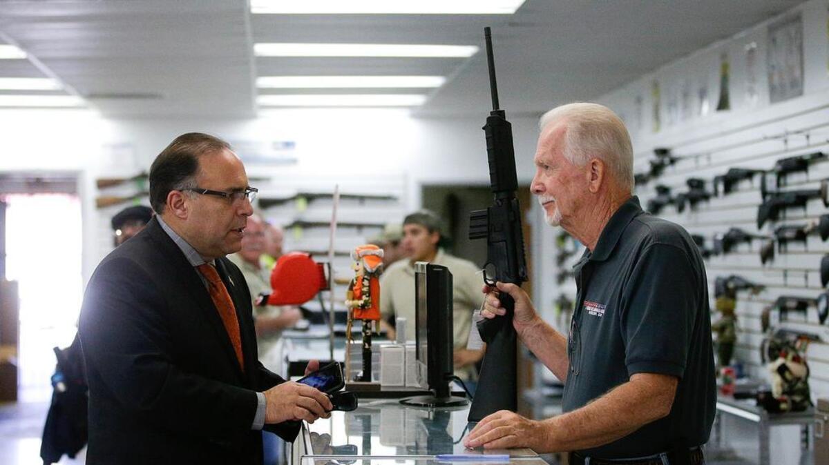 Un vendedor muestra un fusil semiautomático a un cliente en una armería de Riverside, en California, en diciembre del 2015.