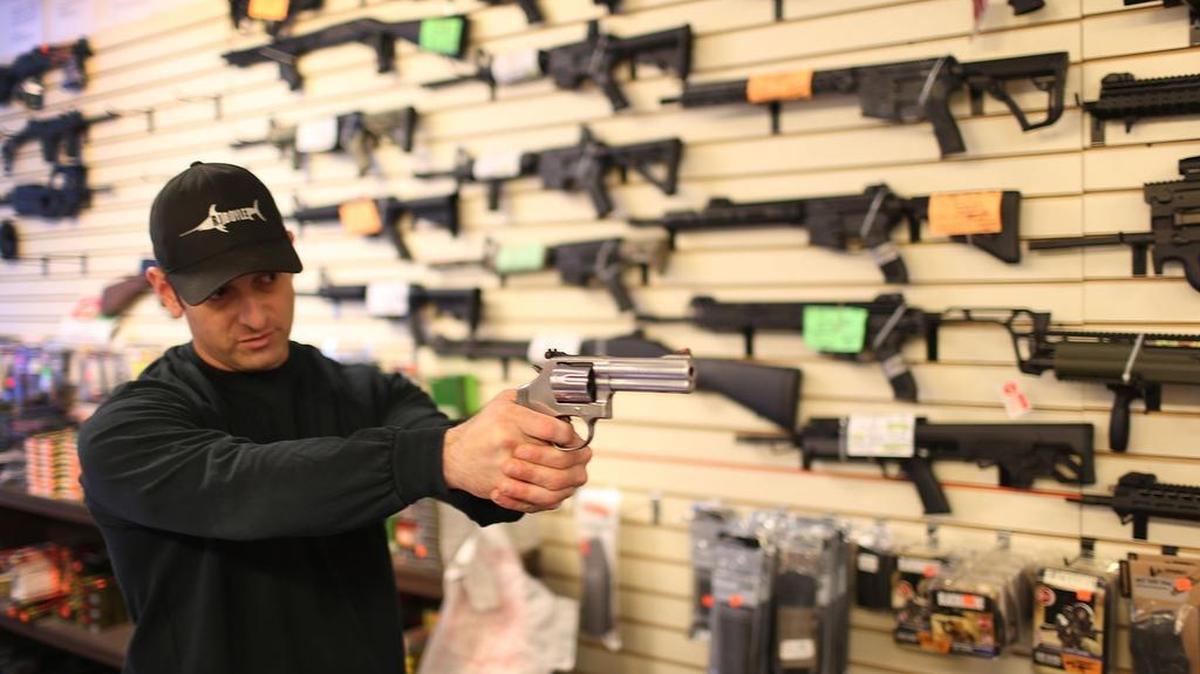 Un empleado de una armería en Delray Beach muestra una pistola el pasado 5 de enero, el día en que el presidente Obama anunció medidas ejecutivas para controlar mejor la venta de armas de fuego.