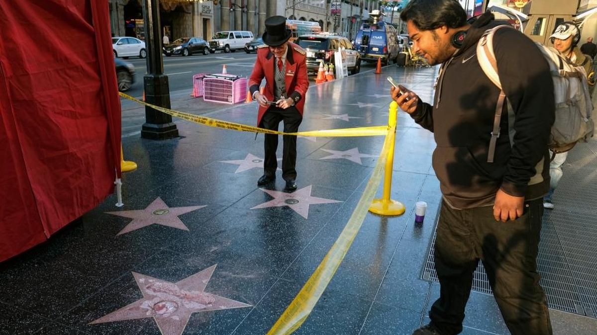 Un hombre toma una foto de la estrella del candidato republicano Donald Trump en el Paseo de la Fama de Hollywood, después que la estrella fue destrozada a martillazos el 26 de octubre.